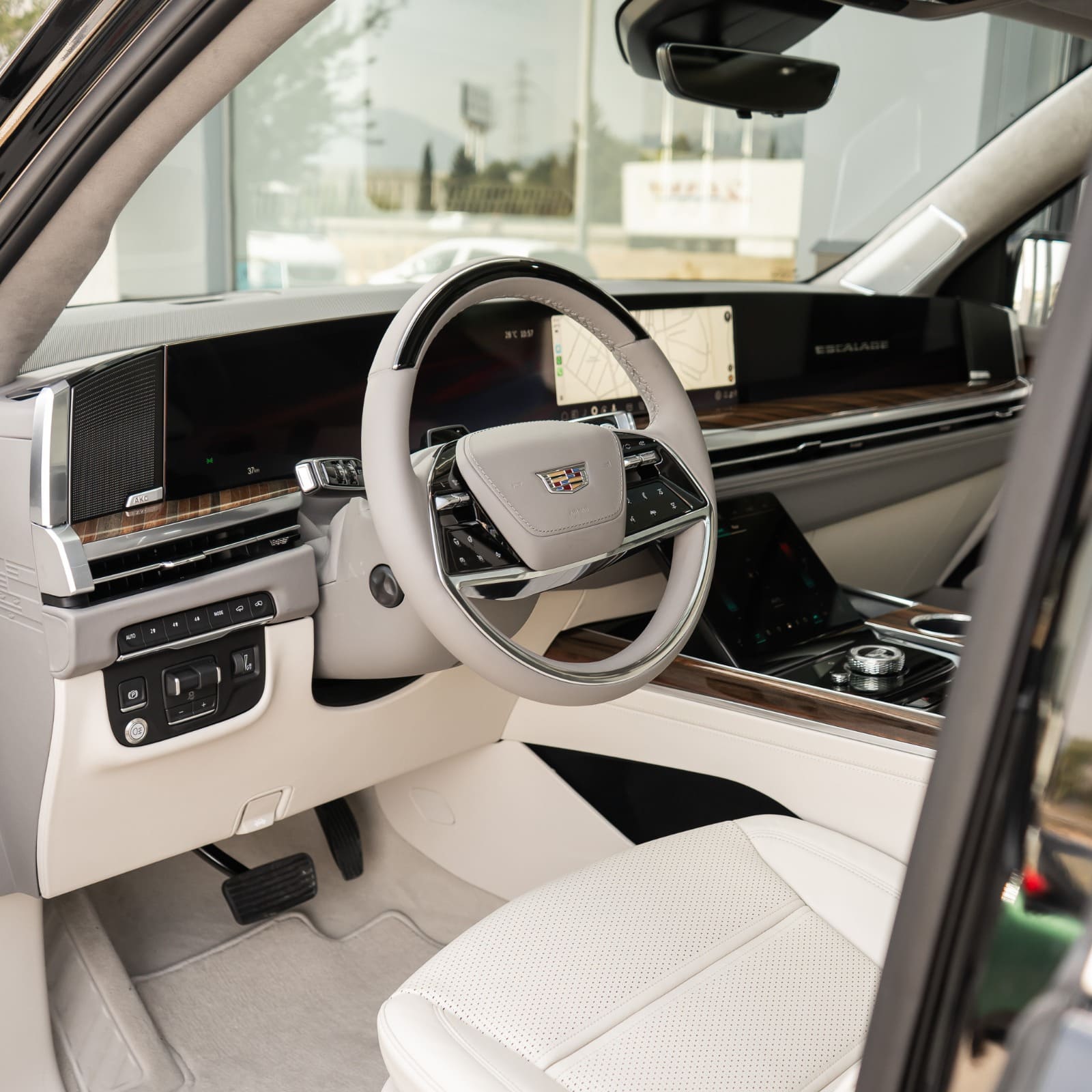 Puesto de conducción del Cadillac Escalade Platinum con pantalla curva HD de 55 pulgadas e interior en cuero Whisper Beige