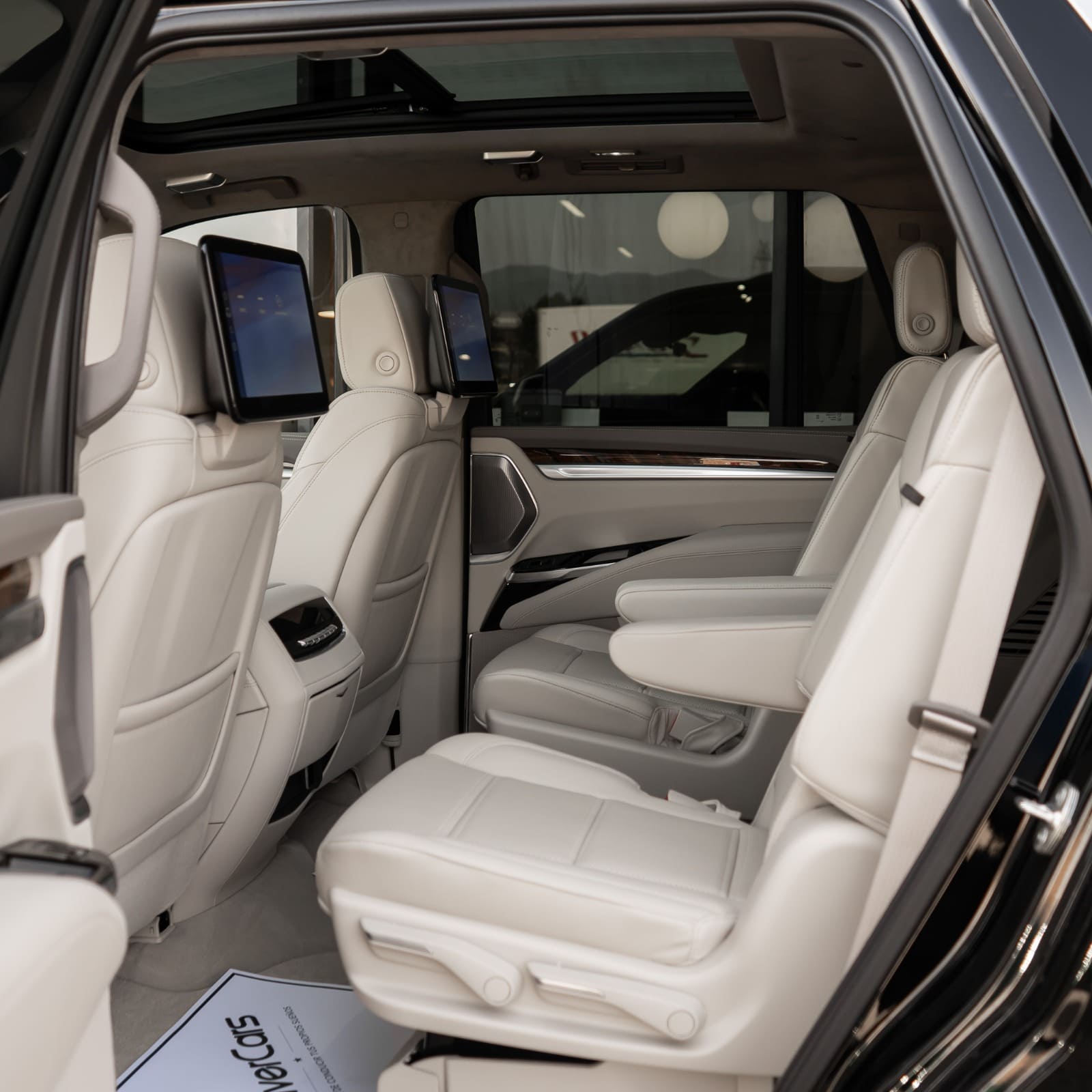 Segunda fila del Cadillac Escalade con executive captain chairs en cuero Whisper Beige y pantallas traseras