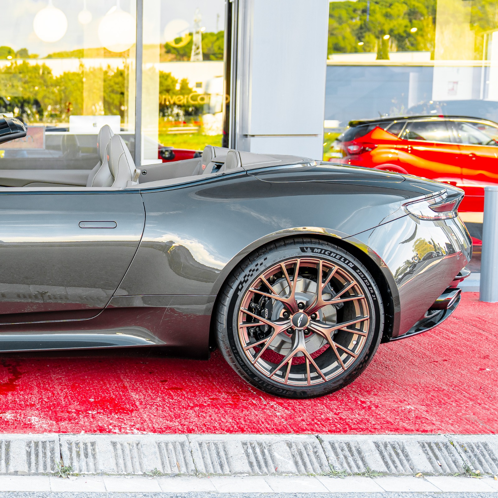 Lateral trasero del Aston Martin DB12 Volante en Cumberland Grey con llanta Satin Bronze