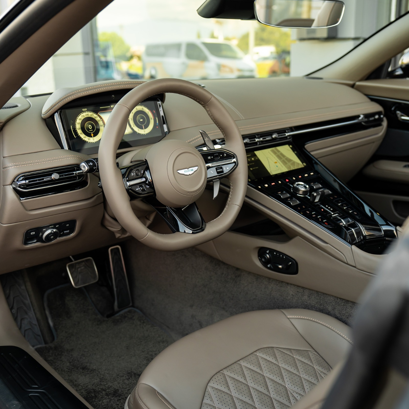 Puesto de conduccion del Aston Martin DB12 Volante con interior Bison Brown y cuadro digital