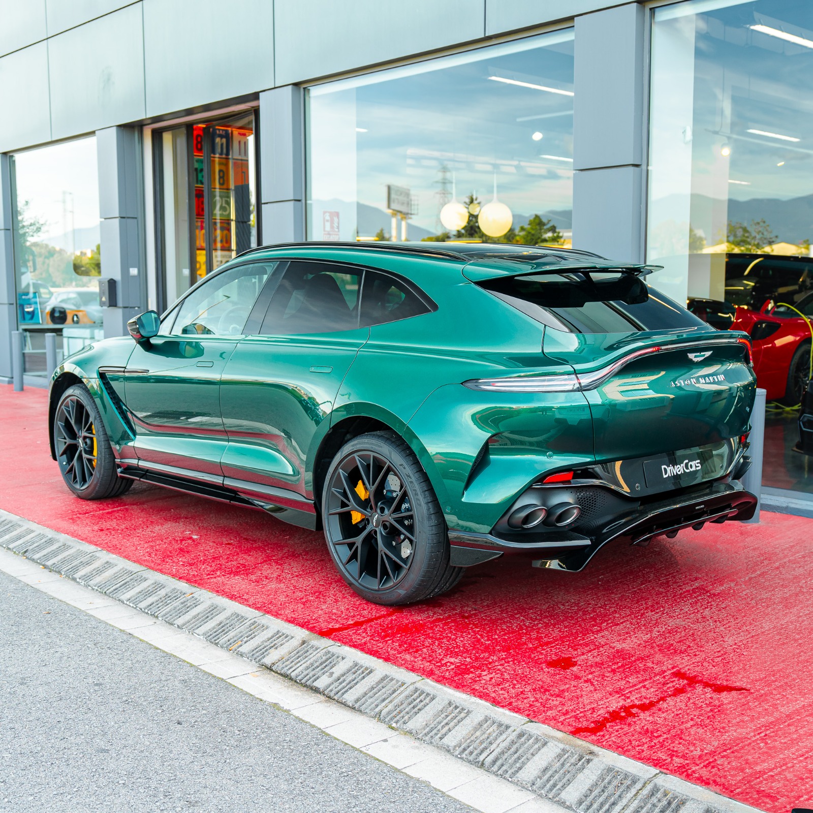 Aston Martin DBX 707 Malachite Green en tres cuartos trasero con el porton y el aleron